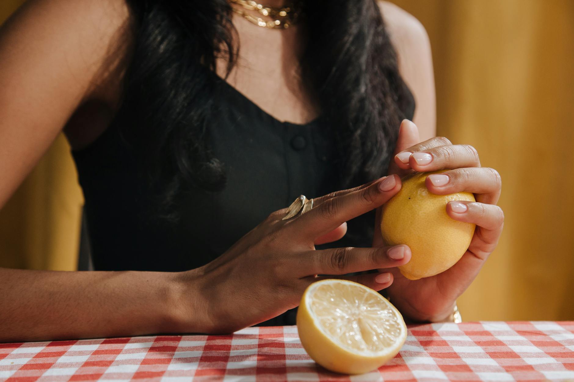 Blue vibrator surrounded by flowers and citrus on a yellow background