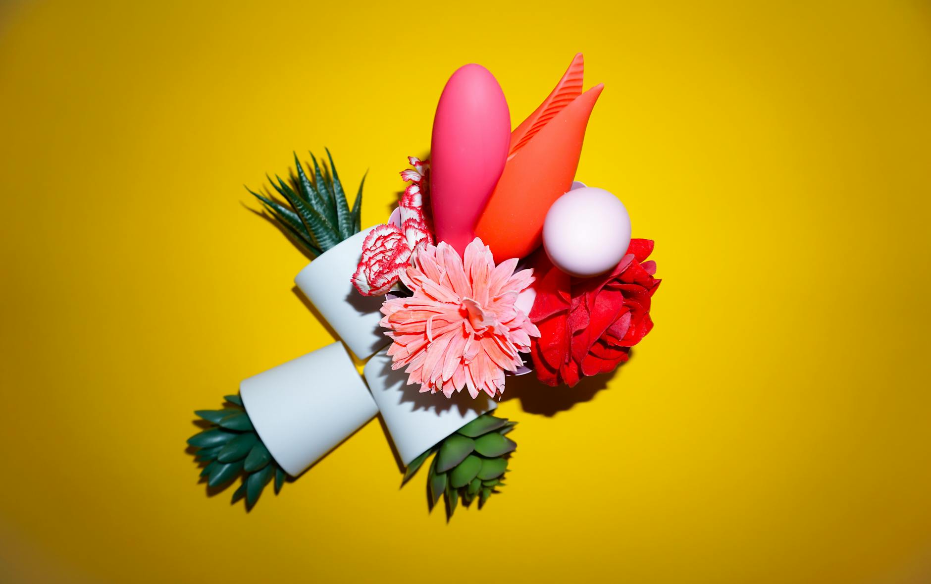A person holding a basket of colorful vibrators including lemon clitoral toys with vibrant flowers